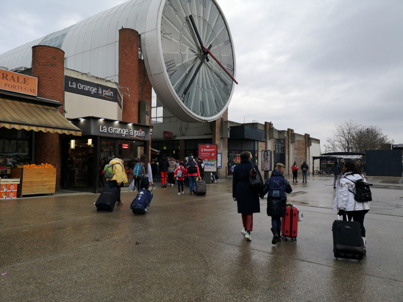 Des enfants vont à la gare avec leur valise