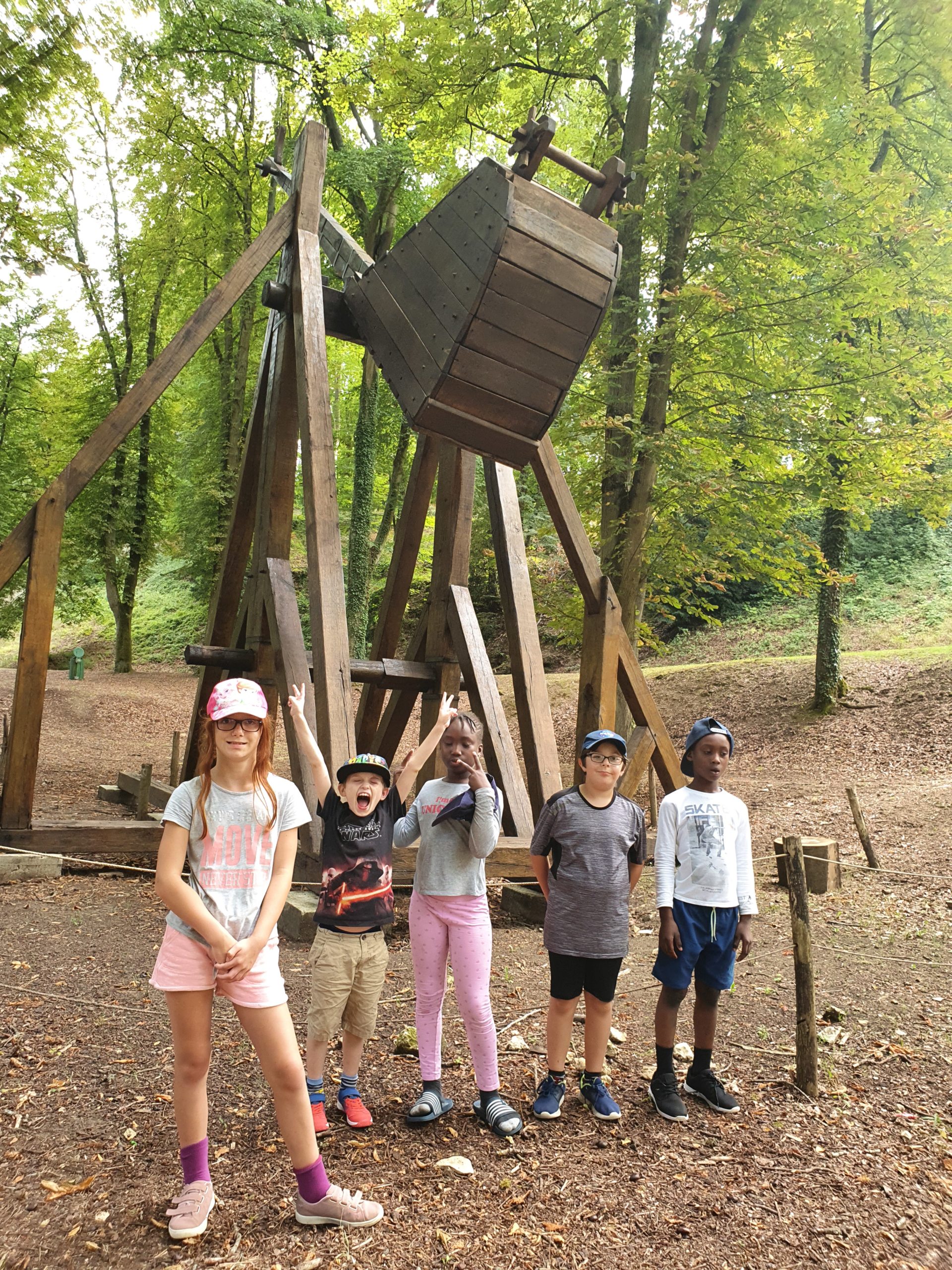 Des enfants devant une catapulte