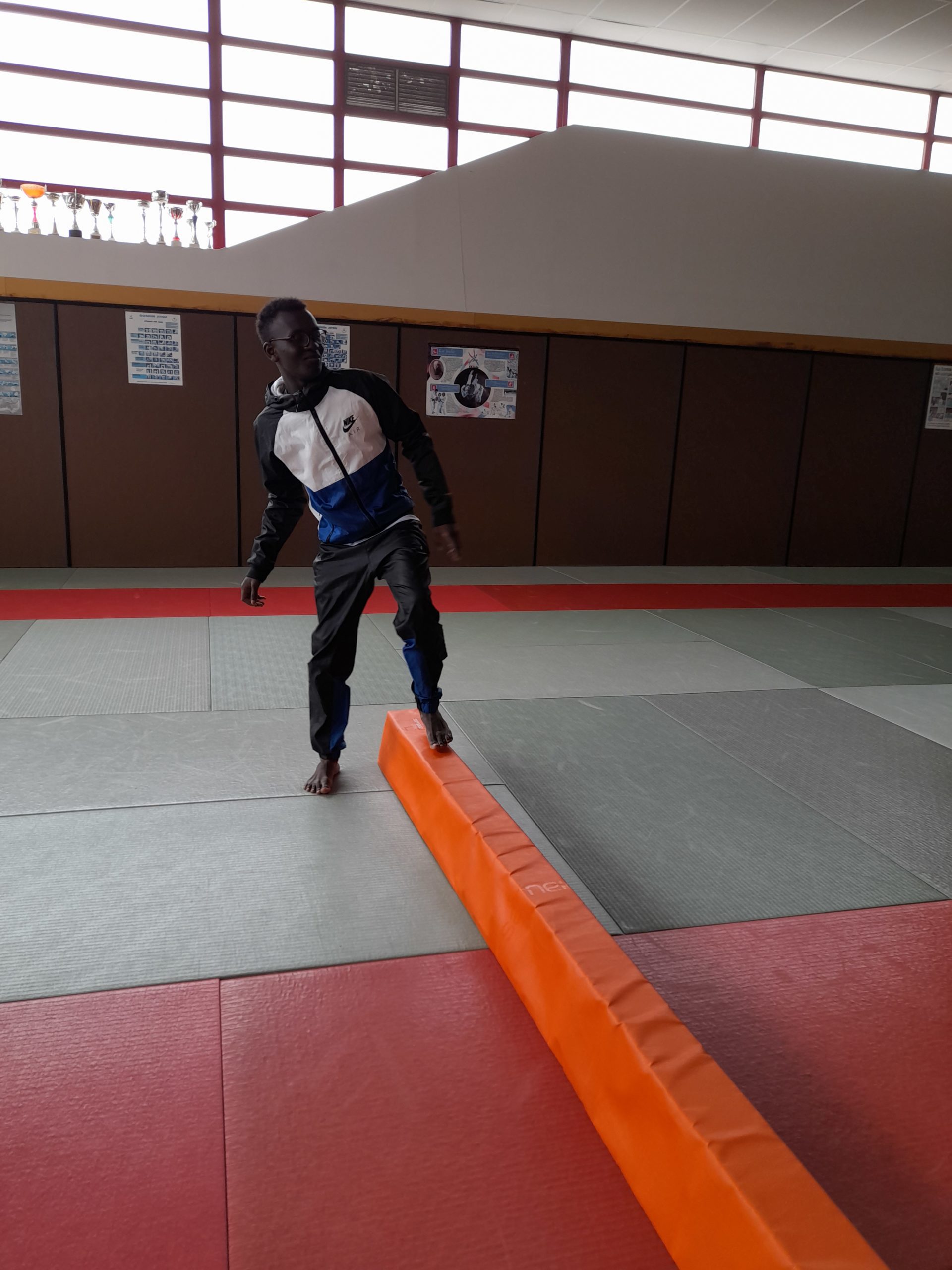 Une garçon commence à marcher sur une barre au sol