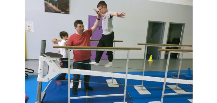 Un jeune marche sur un câble à quelques centimètres du sol