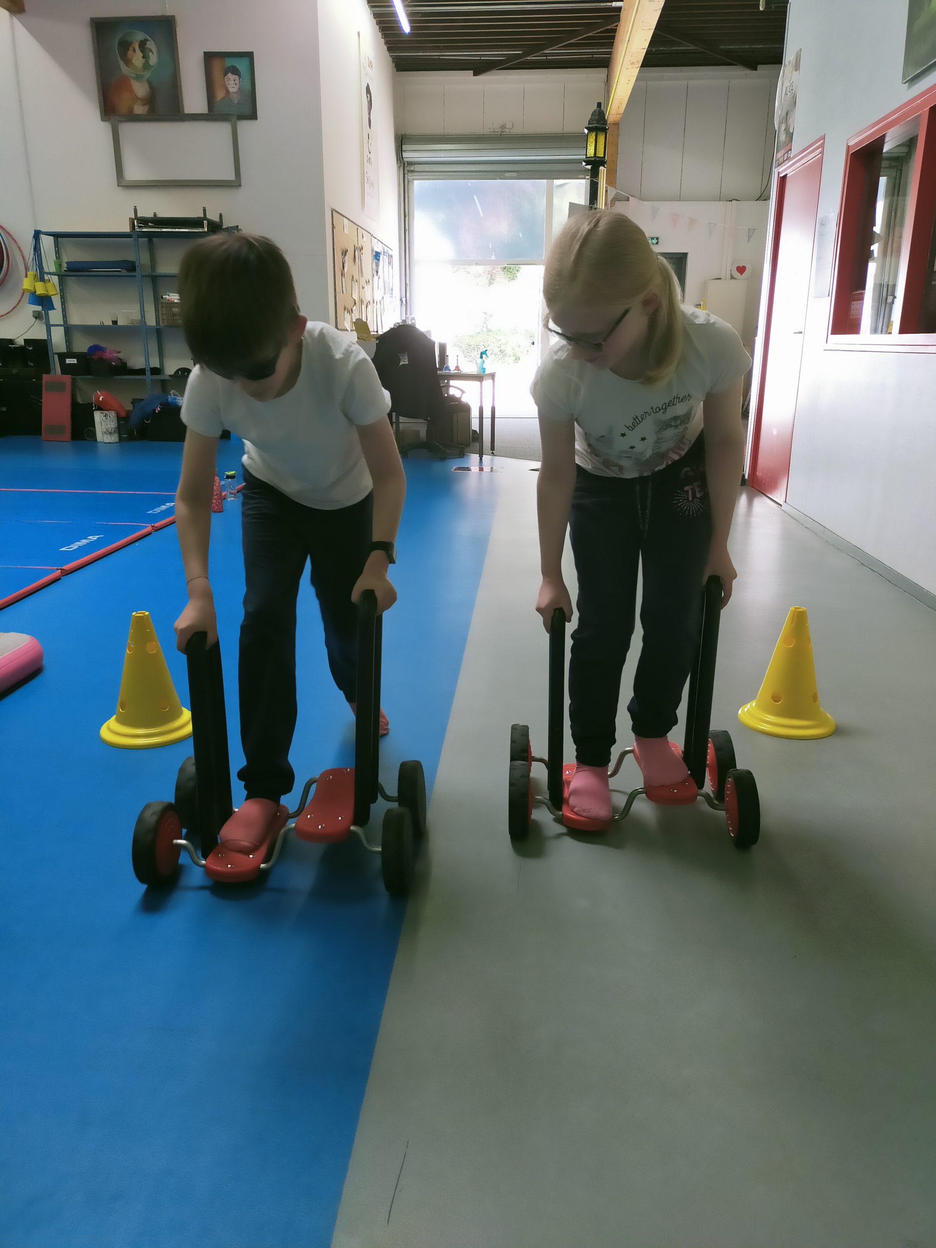 Deux jeunes se déplaceent sur un appareil à roulettes