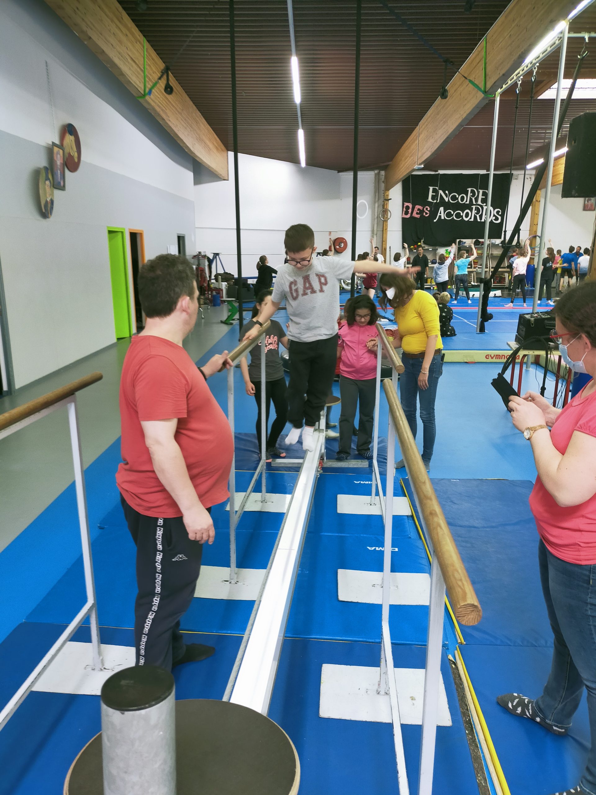 Un jeune marche pied nu sur une barre à quelques centimètres du sol