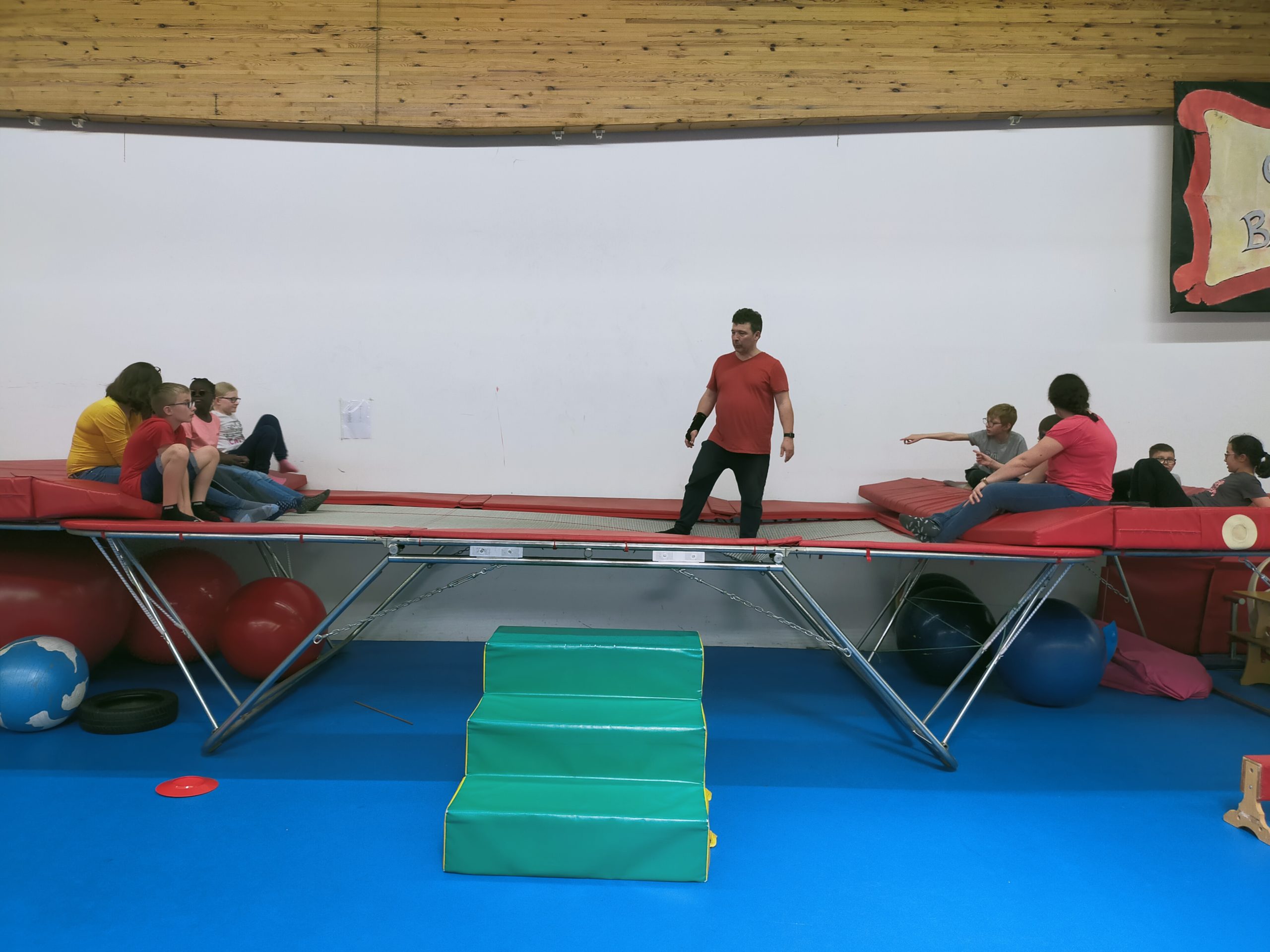 Des jeunes et un adulet sur un grand trempoline