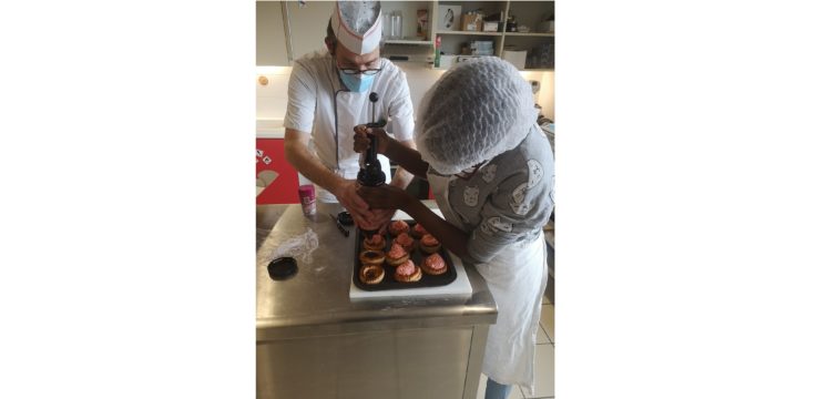 Un jeune et un éducateur réalisant une patisserie